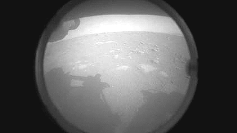 Primeira foto enviada pela Mars Perseverance quatro minutos aps o pouso. No horizonte temos a borda cratera Jezero.